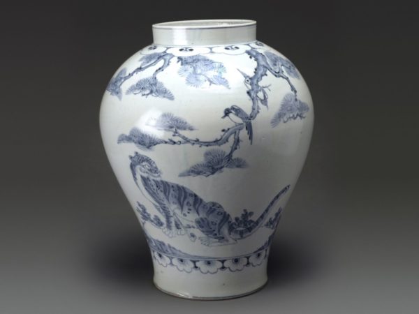 A wide-mouthed white porcelain jar with a tiger and magpie painted in blue.