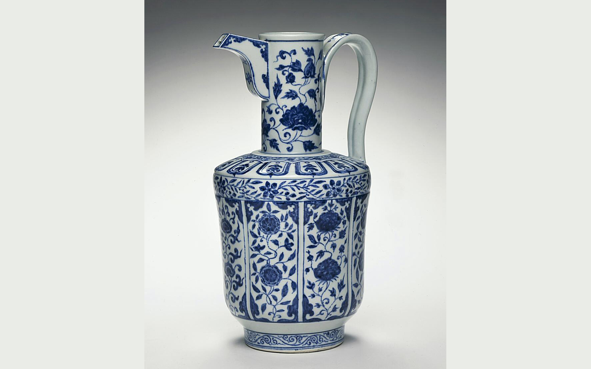 Spouted blue and white porcelain pitcher with floral designs.