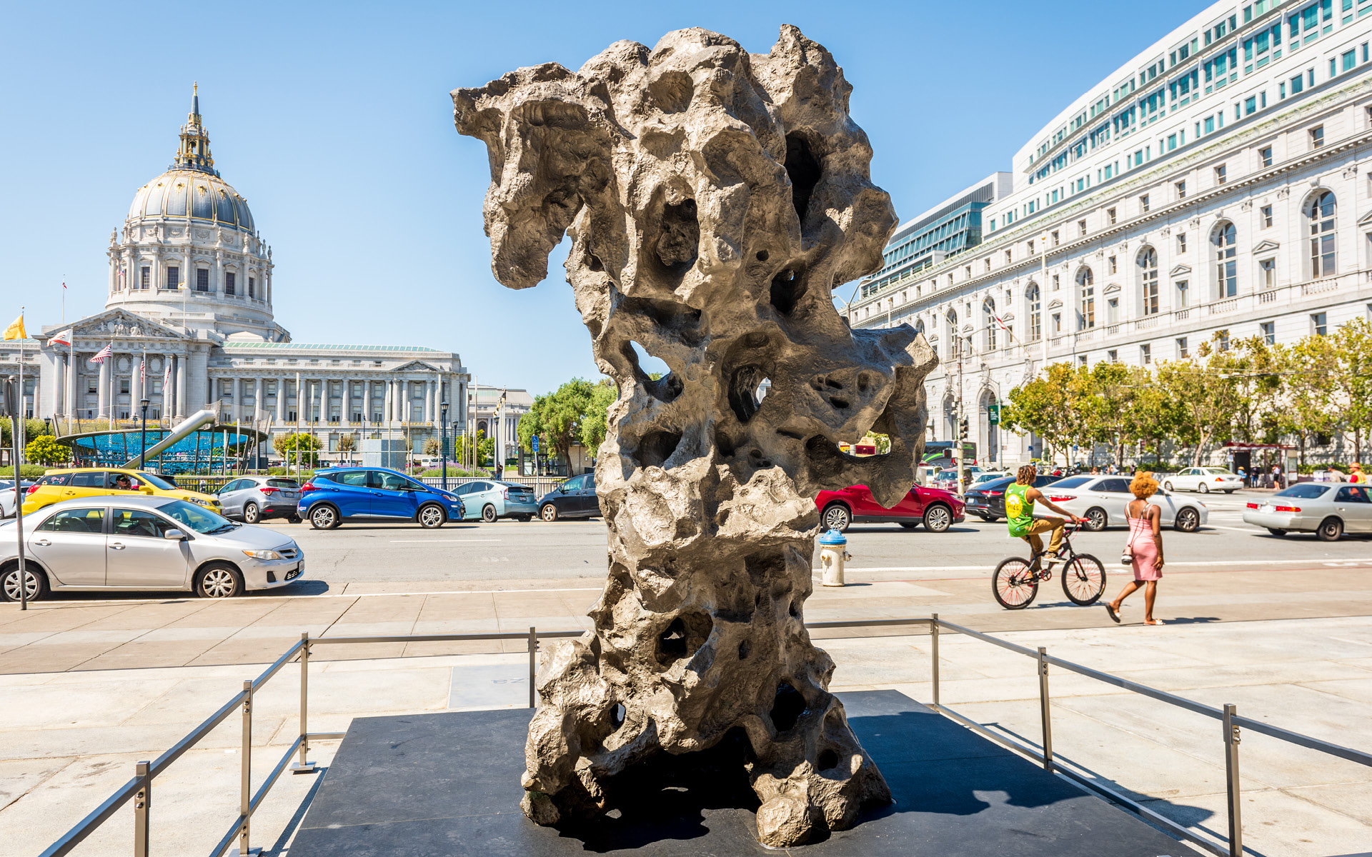 A tall craggy rock made of metal standing in front of the Asian Art Museum.