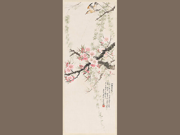 Painted vertical hanging scroll on cream colored paper with a bird descending onto branches full of pink blossoms.